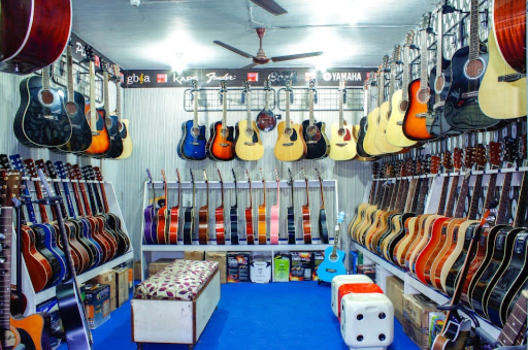 Guitar,String instrument,Plucked string instruments,Musical instrument,Room,Acoustic guitar,Building,Retail,Acoustic-electric guitar,Athletic shoe