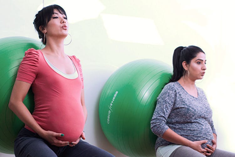 People,Green,Swiss ball,Ball,Physical fitness,Mother,Leisure,Sitting,Abdomen,Child