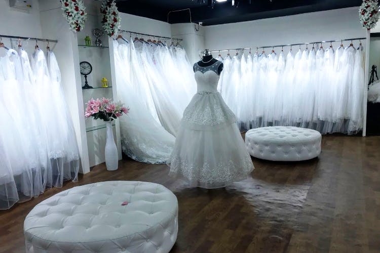 Dress,Gown,Wedding dress,Bridal clothing,Room,Bride,Floor,Function hall,Interior design,Flooring