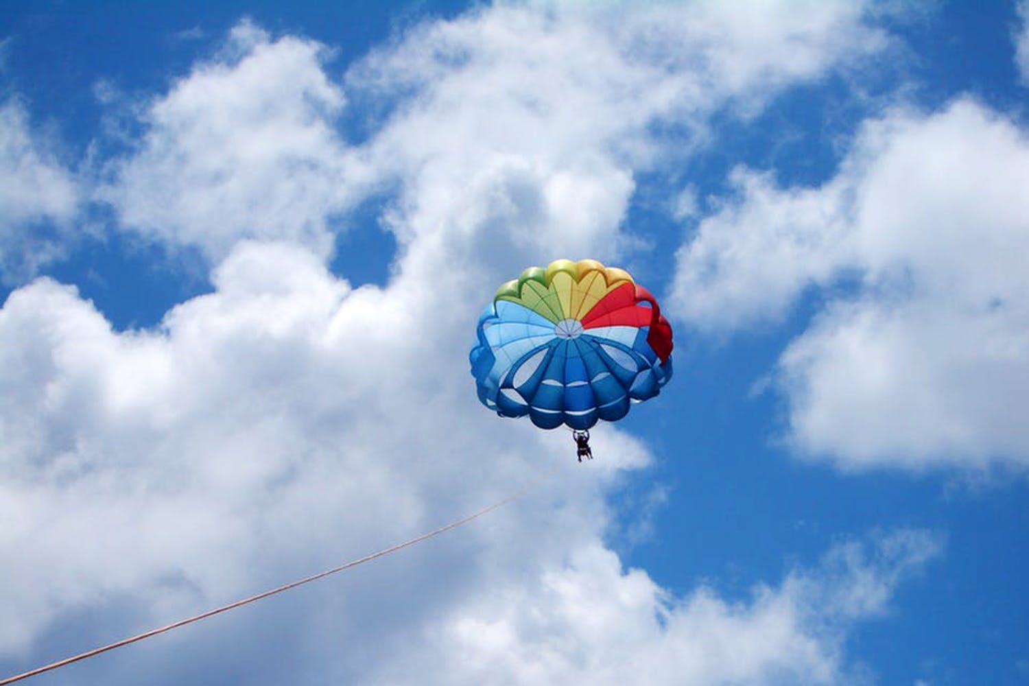 Sky,Parasailing,Parachute,Cloud,Daytime,Mode of transport,Cumulus,Parachuting,Kite sports,Fun