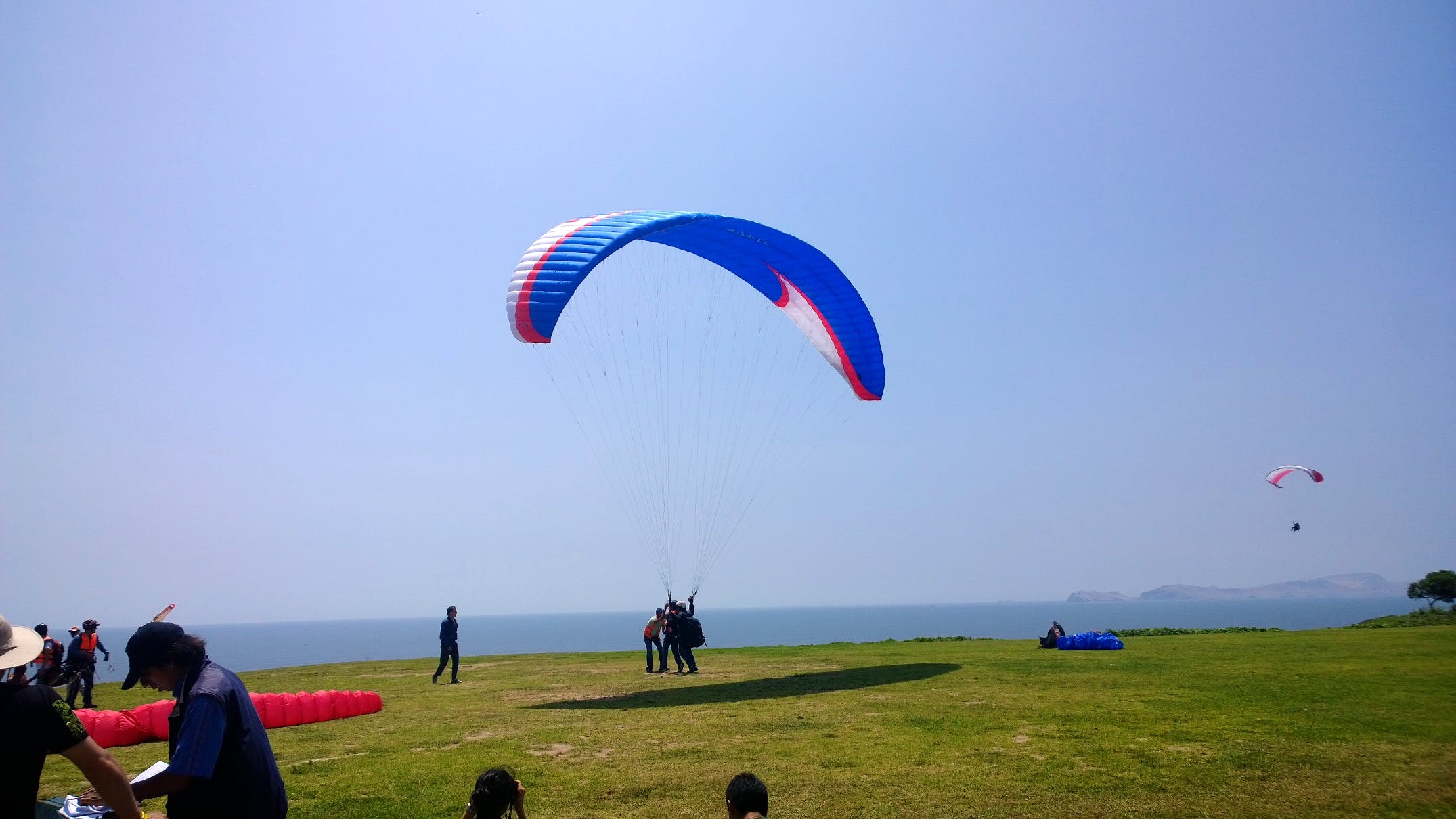 Parachute,Paragliding,Parachuting,Air sports,Sky,Horizon,Cloud,Grassland,Windsports,Fun