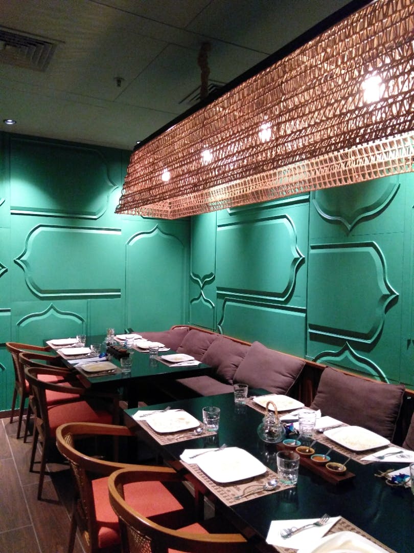 Green,Room,Restaurant,Turquoise,Lighting,Interior design,Wall,Ceiling,Building,Table