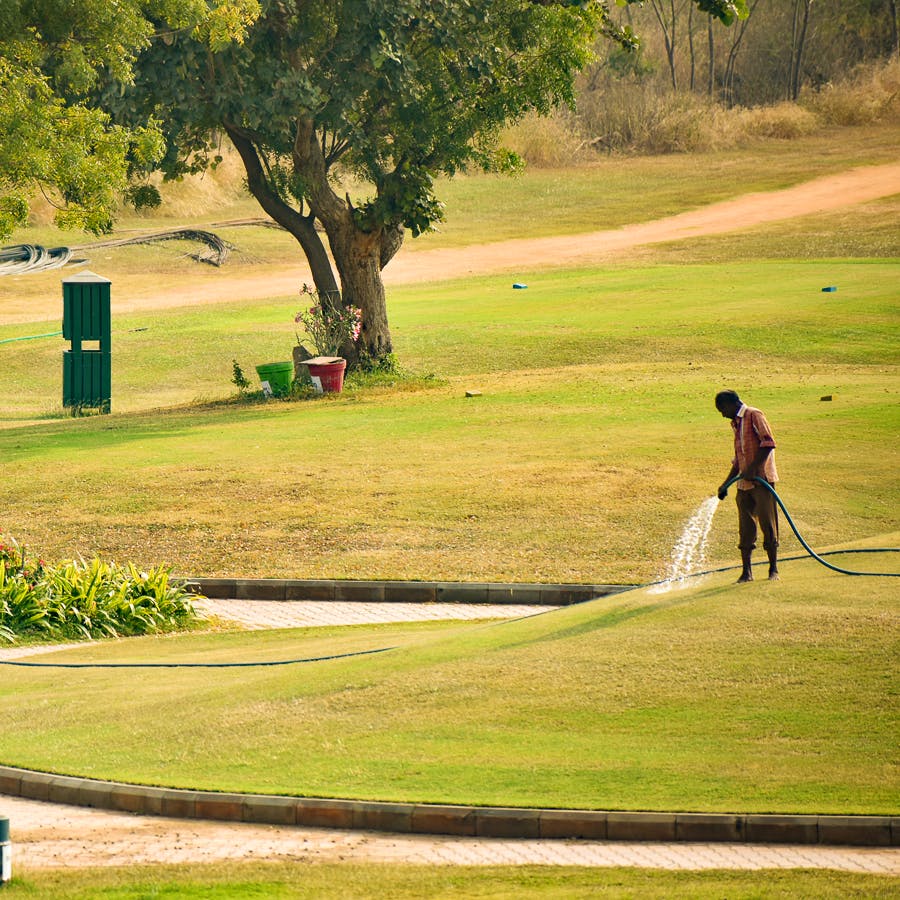 Sport venue,Golfer,Golf,Golf course,Green,Golf club,Sky,Professional golfer,Lawn,Standing