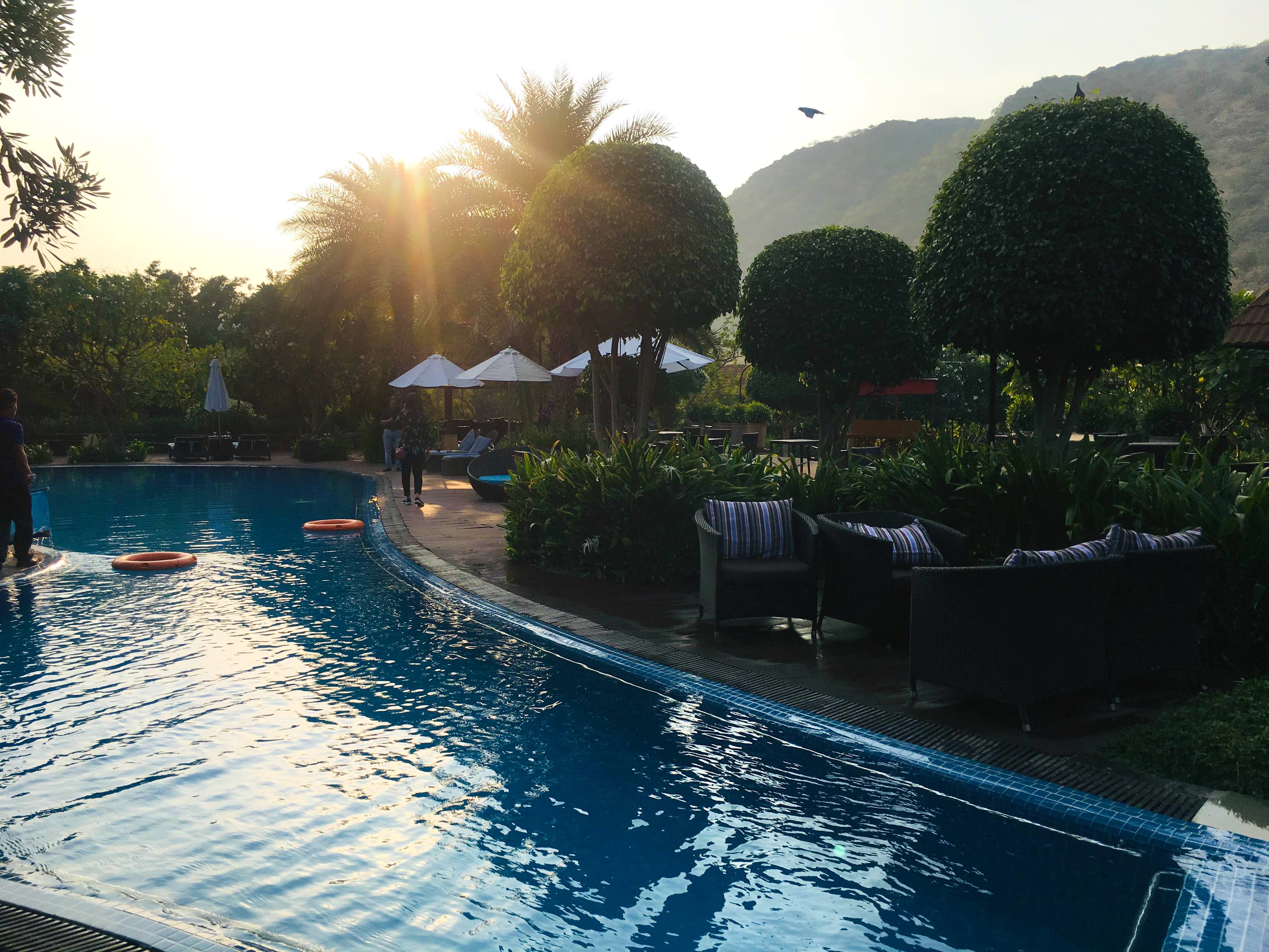 Swimming pool,Sky,Water,Tree,Vacation,Leisure,Resort,Palm tree,Reflecting pool,Summer