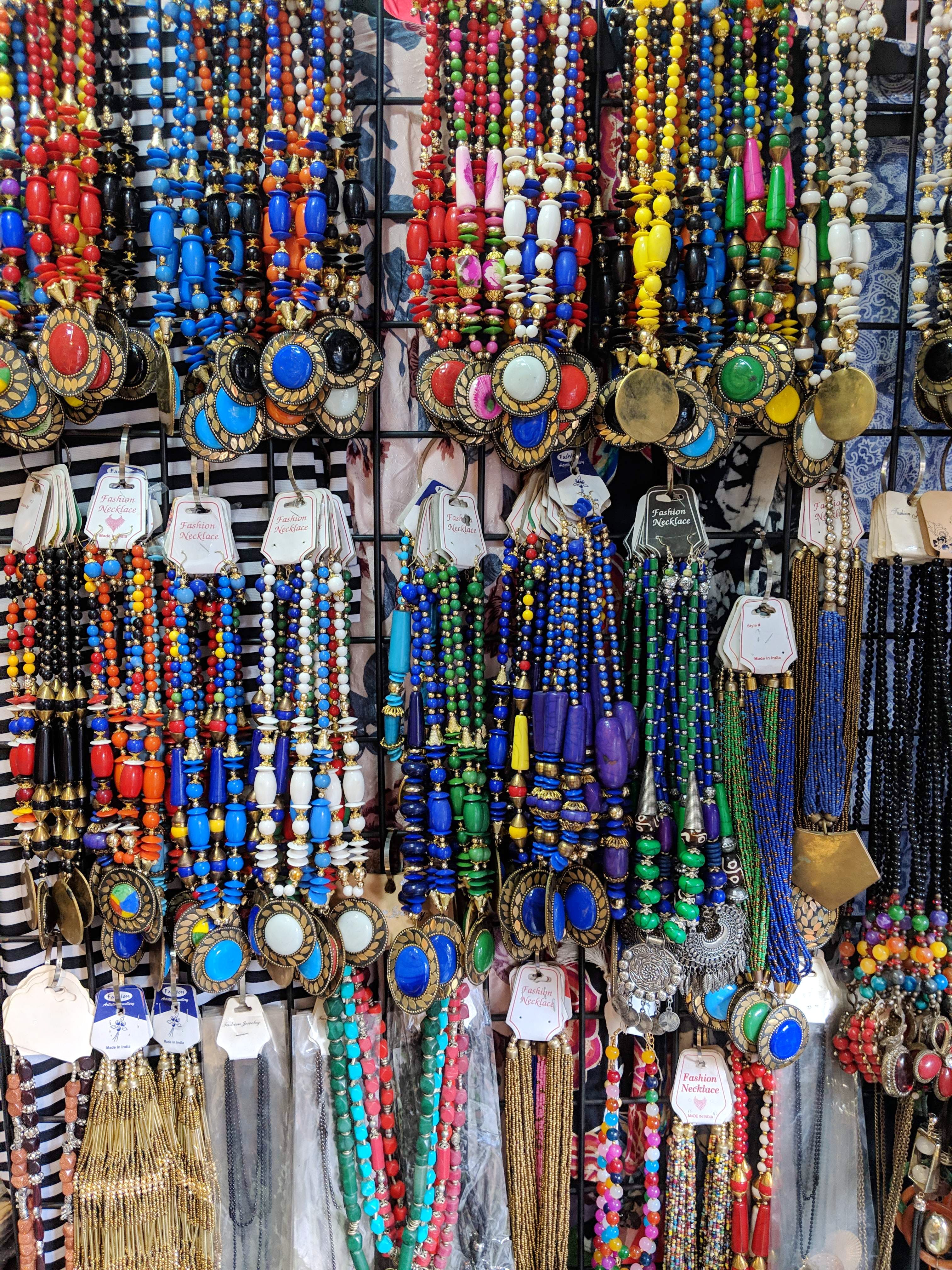 Religious item,Public space,Fashion accessory,Human settlement,Bazaar,Necklace,Jewellery,Bead,City,Market