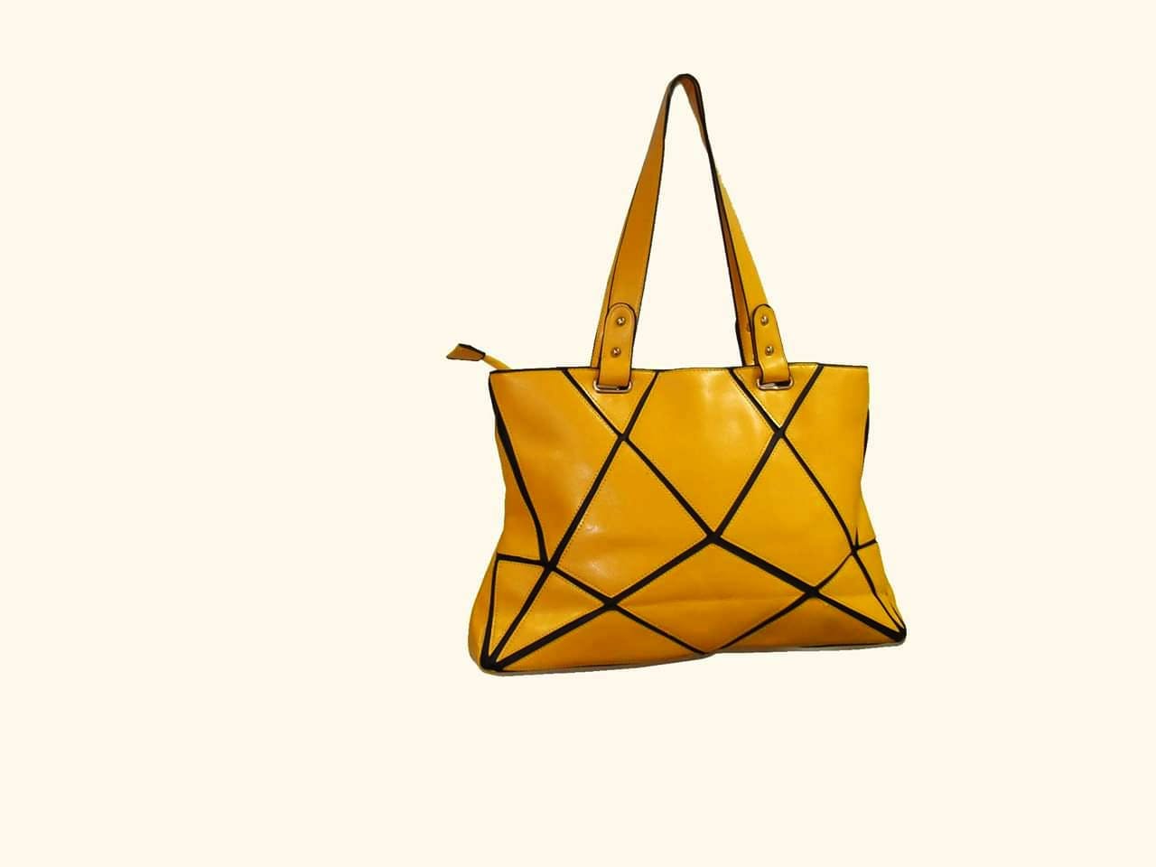 Bag,Handbag,Yellow,Shoulder bag,Fashion accessory,Triangle,Hobo bag,Font,Tote bag,Triangle