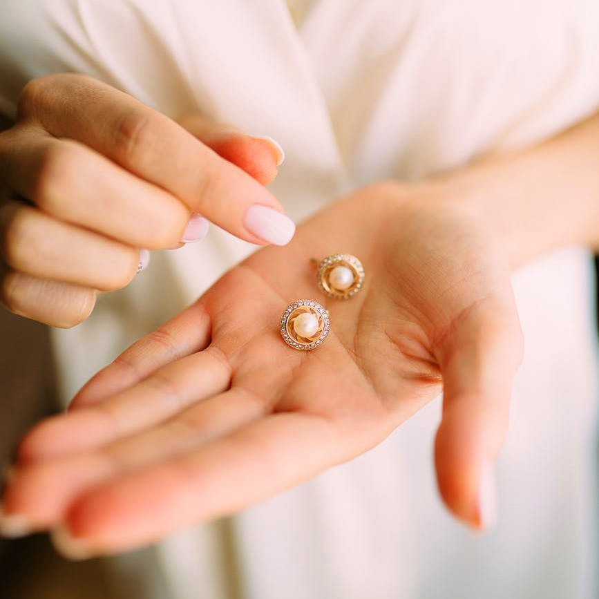 Hand,Finger,Pearl,Skin,Nail,Yellow,Ring,Jewellery,Fashion accessory,Gesture