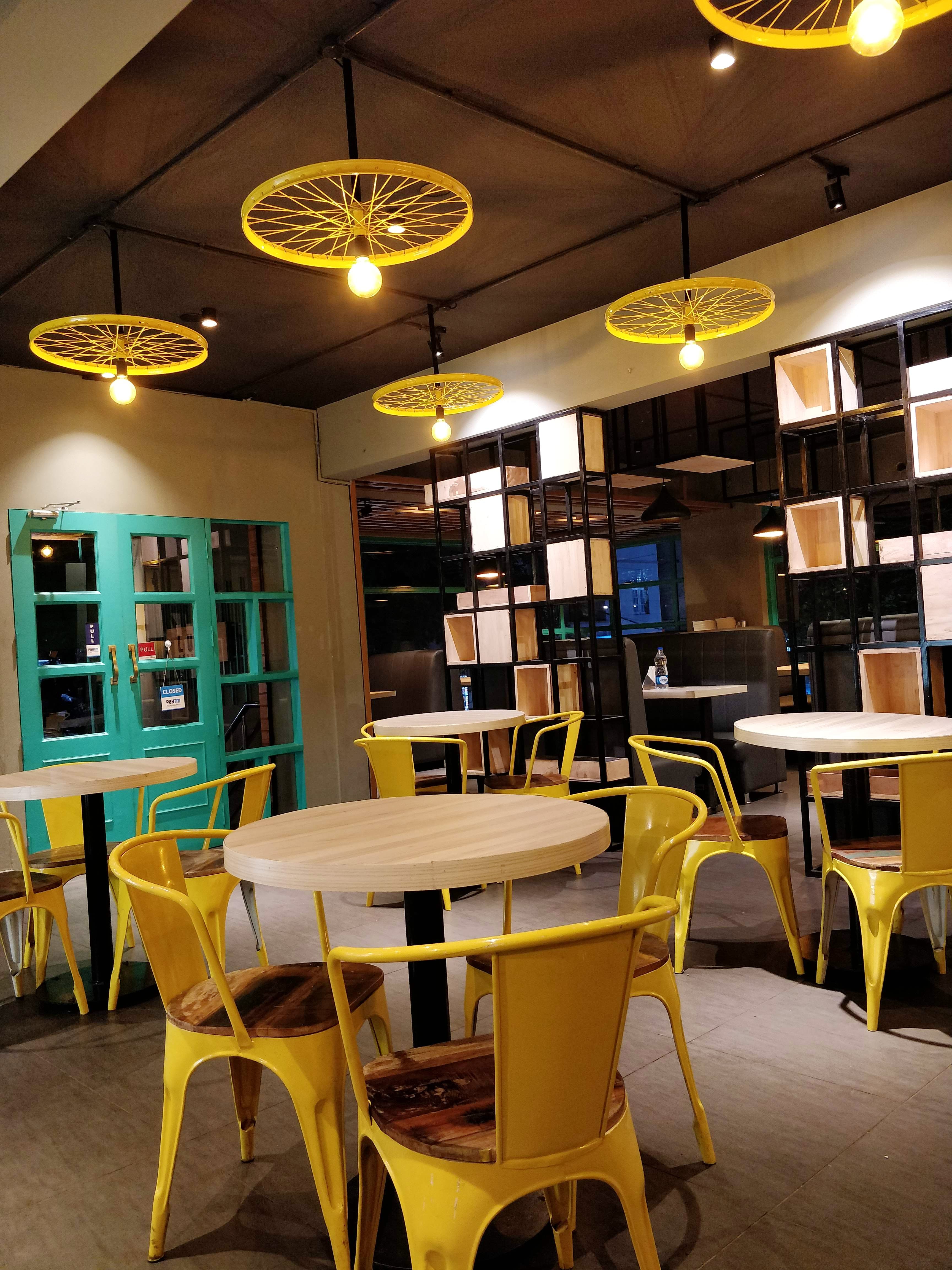 Building,Room,Restaurant,Interior design,Lighting,Yellow,Table,Furniture,Café,Kitchen & dining room table