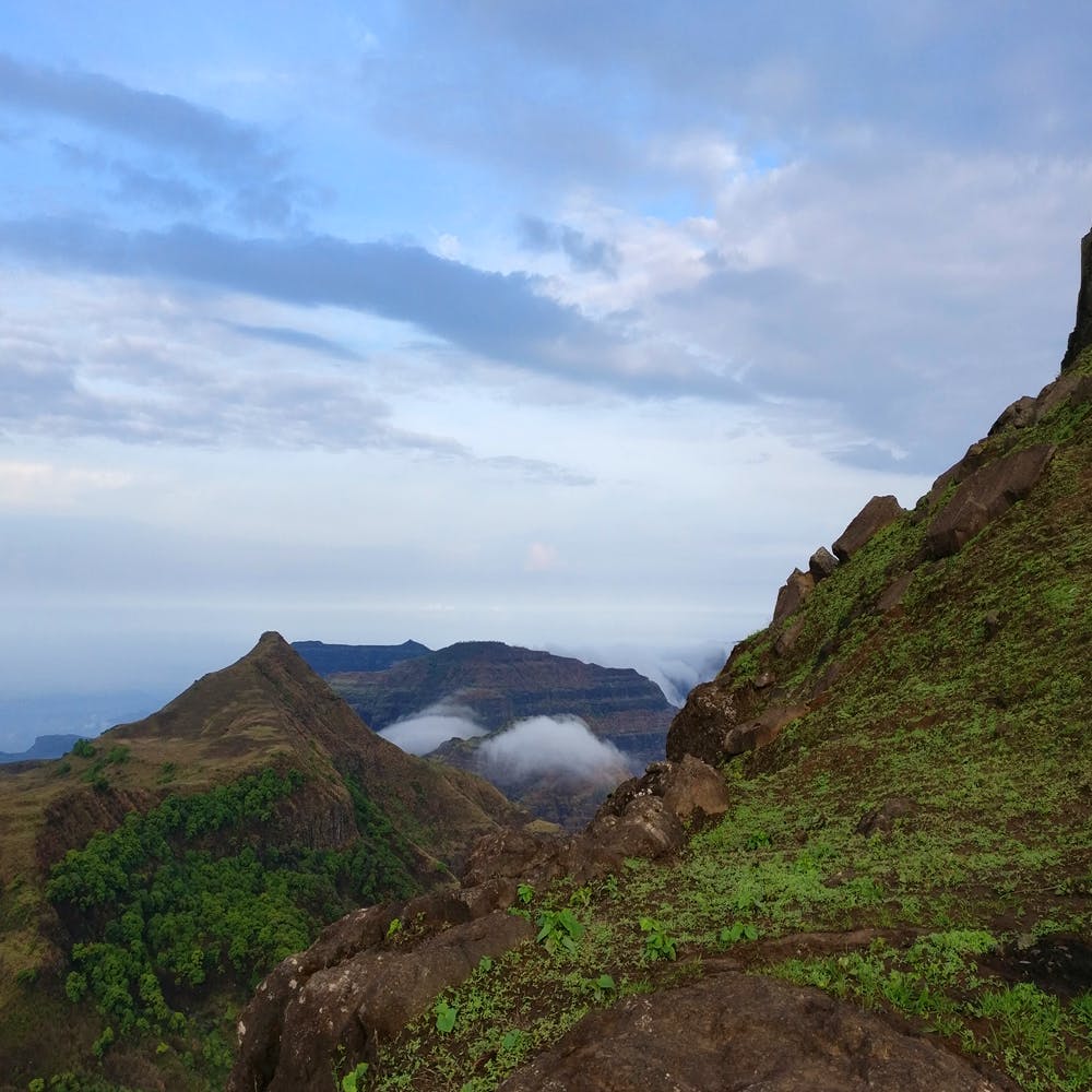 Highland,Mountainous landforms,Sky,Mountain,Hill,Natural landscape,Atmospheric phenomenon,Wilderness,Fell,Cloud