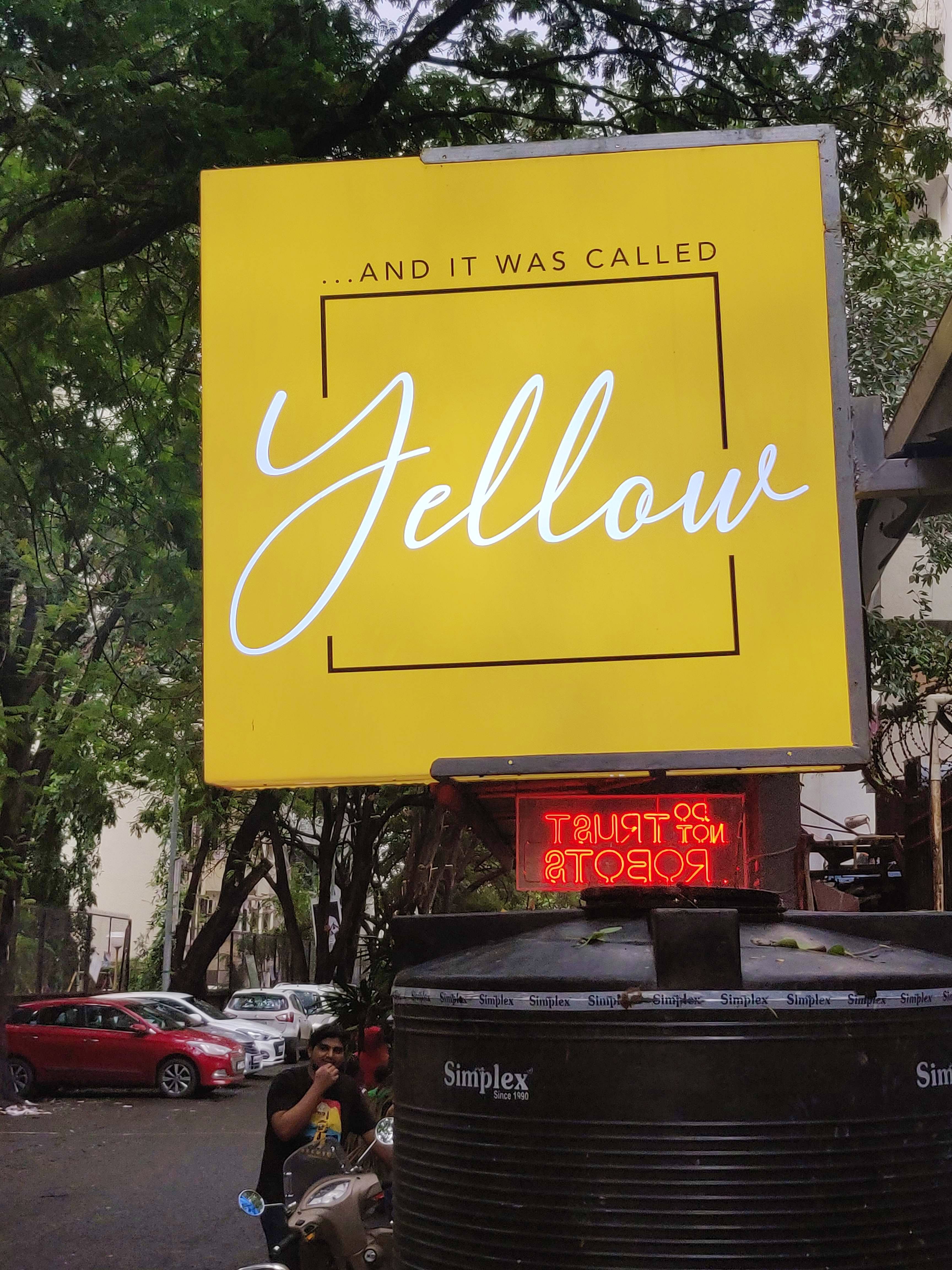 Motor vehicle,Yellow,Font,Signage,Advertising,Sign,Architecture,Road,Vehicle,Electronic signage