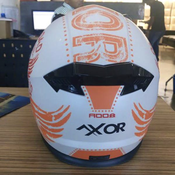 Motorcycle helmet,Helmet,Personal protective equipment,Orange,Sports equipment,Ball,Headgear,Soccer ball,Football,Rugby ball
