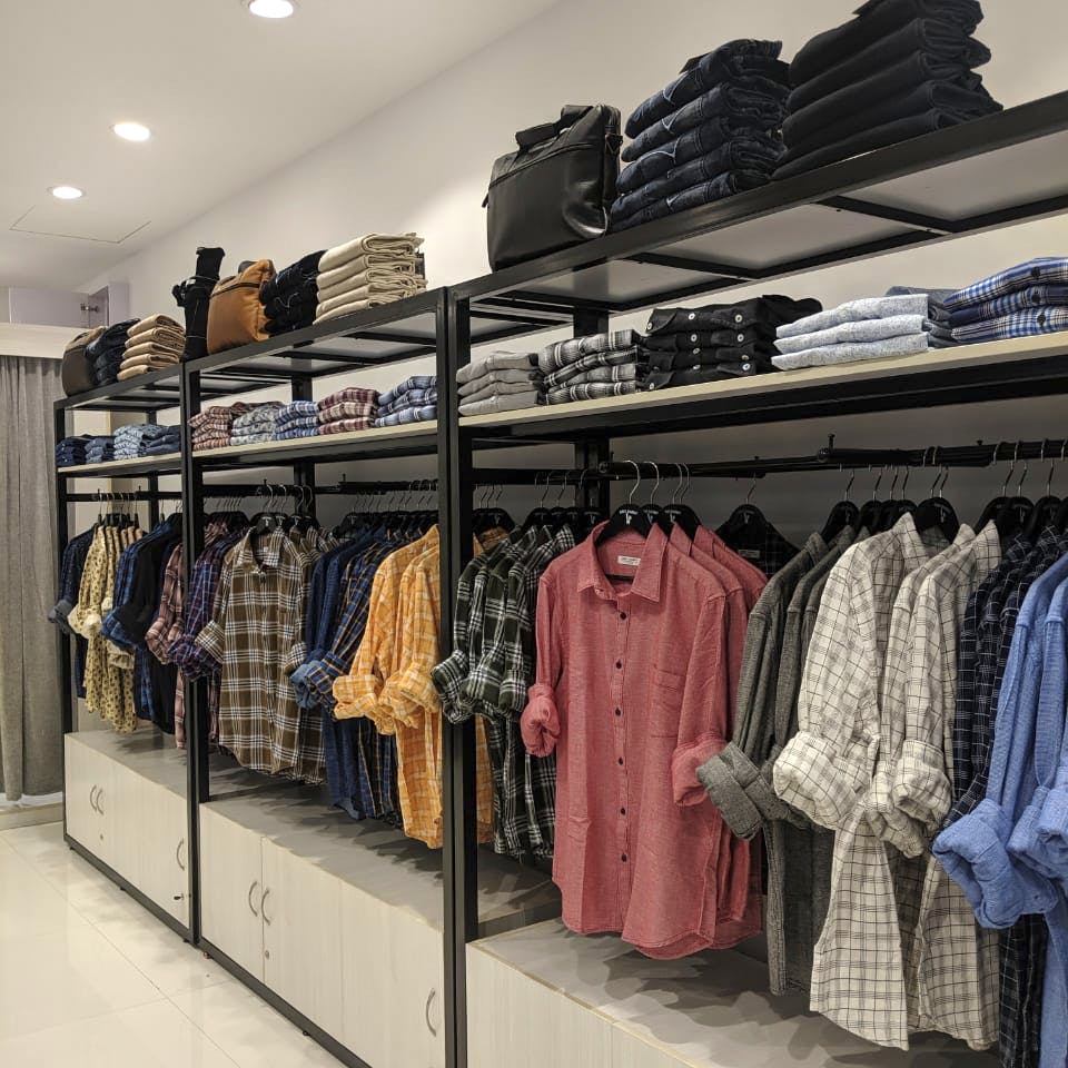 Men clothing shop, casual clothes on hangers and shelves in apparel store  Stock Photo