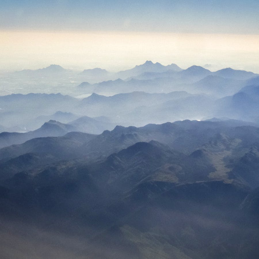 Mountainous landforms,Sky,Mountain,Mountain range,Atmospheric phenomenon,Highland,Ridge,Blue,Cloud,Atmosphere