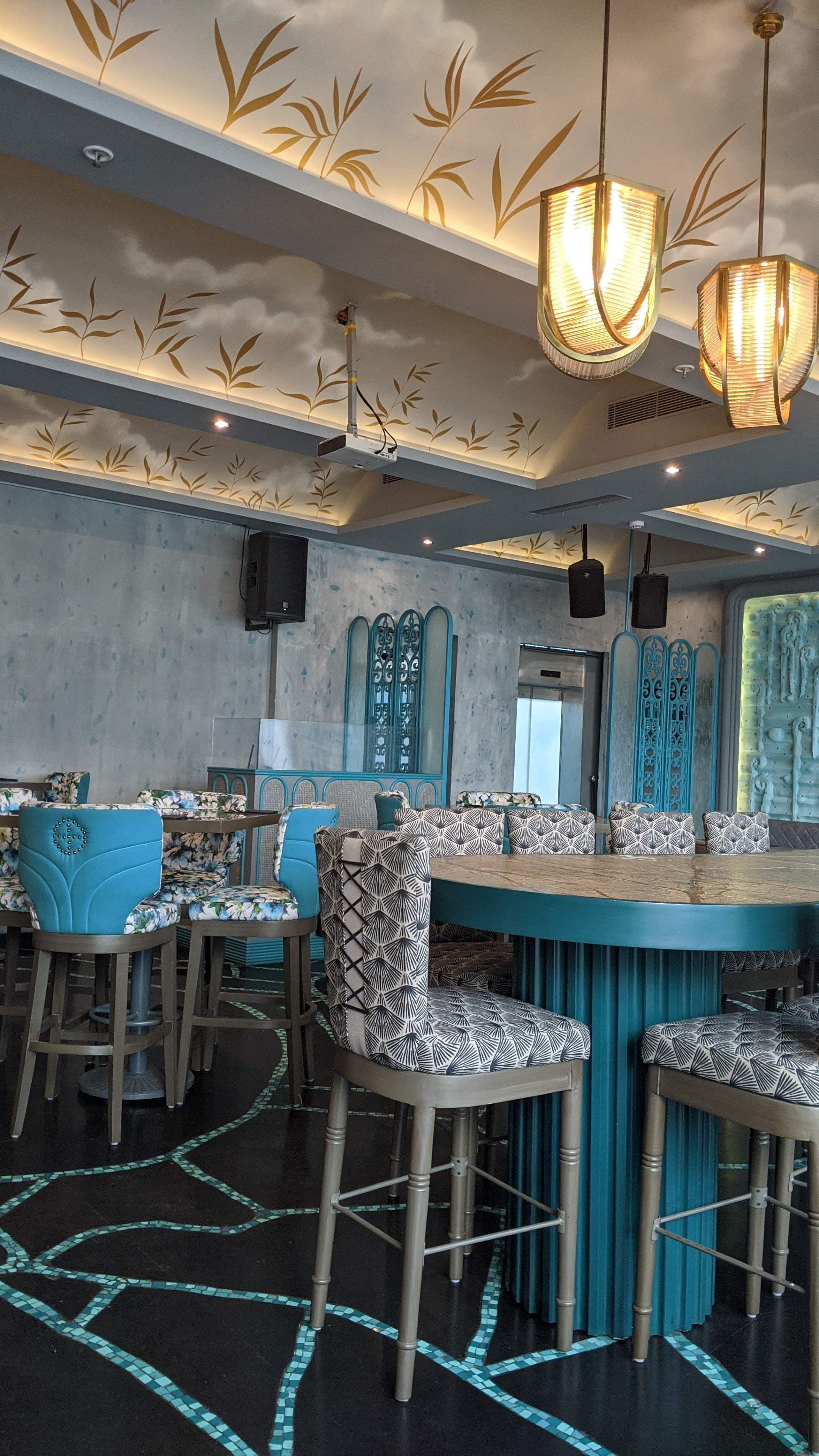 Turquoise,Furniture,Room,Chair,Table,Interior design,Building,Lighting,Ceiling,Restaurant