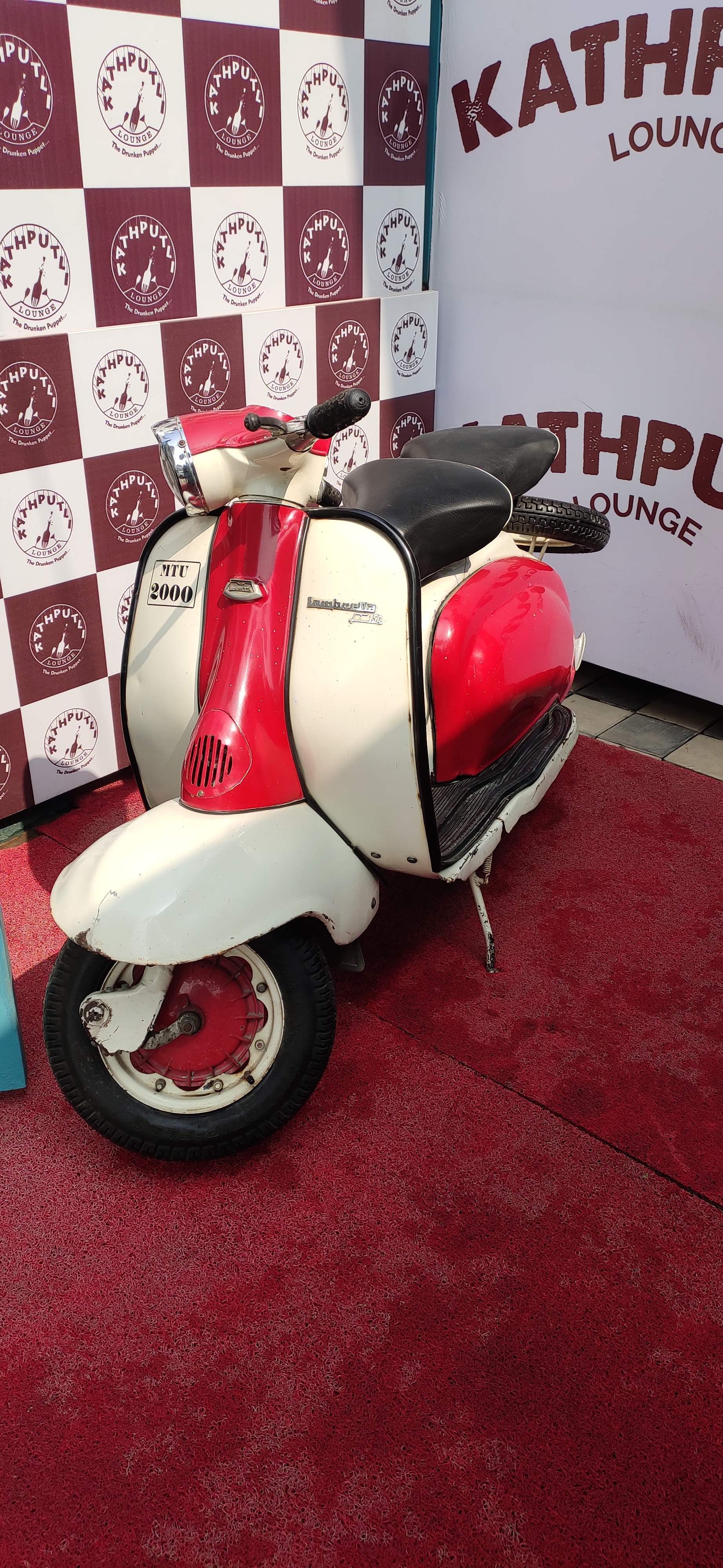 Scooter,Motor vehicle,Vespa,Red,Vehicle,Automotive design,Car,Automotive tire,Tire,Automotive wheel system