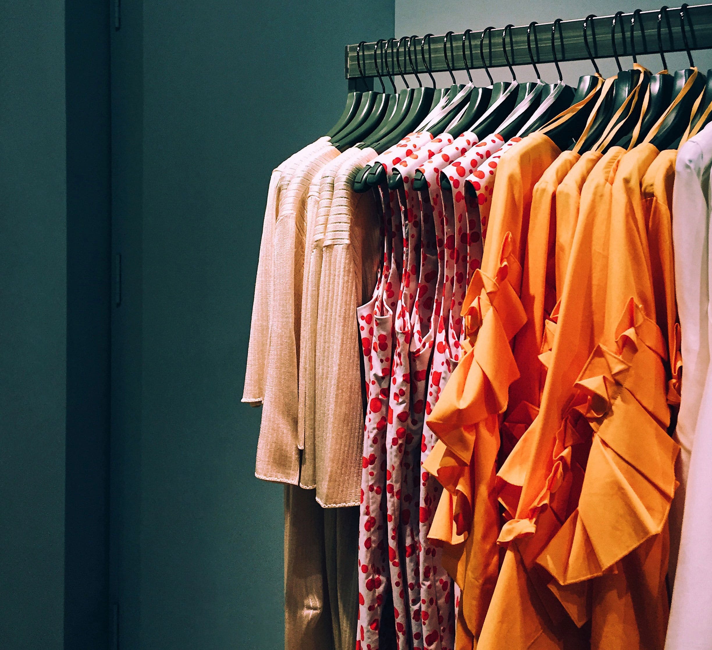 Clothes hanger,Clothing,Orange,Room,Textile,Closet,Boutique,Dress,Home accessories,Fashion design