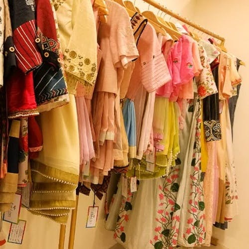 Clothes hanger,Clothing,Room,Boutique,Yellow,Closet,Textile,Peach,Dress,Furniture