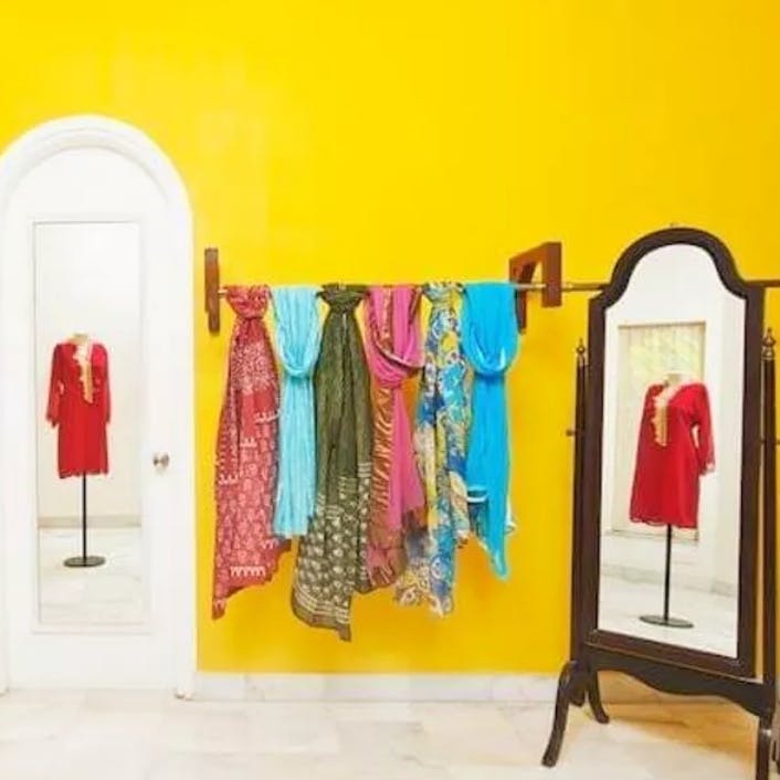 Outerwear,Sleeve,Clothes hanger,Yellow,Door,Fixture,Fashion design,Boutique,Art,Paint