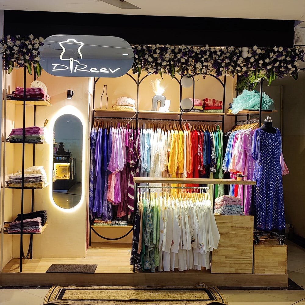 Outerwear,Clothes hanger,Purple,Interior design,Shelf,Retail,Fashion design,Window,Magenta,Boutique