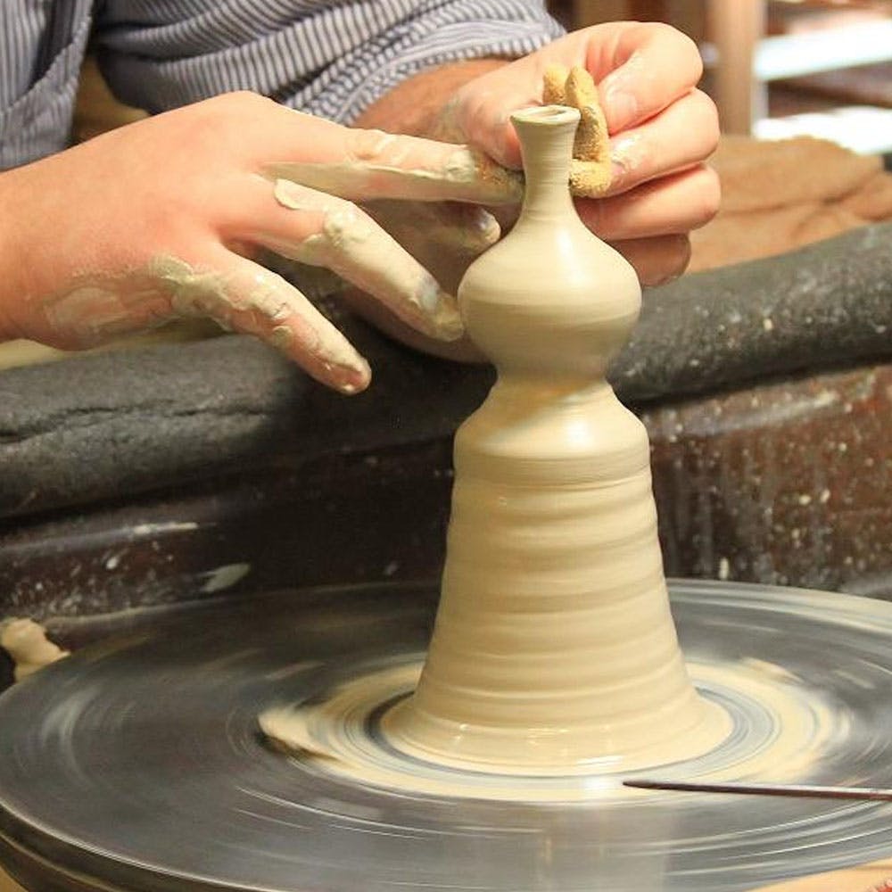 Potter's wheel,Wheel,Wood,Creative arts,Finger,Clay,Gas,Indoor games and sports,Auto part,Thumb