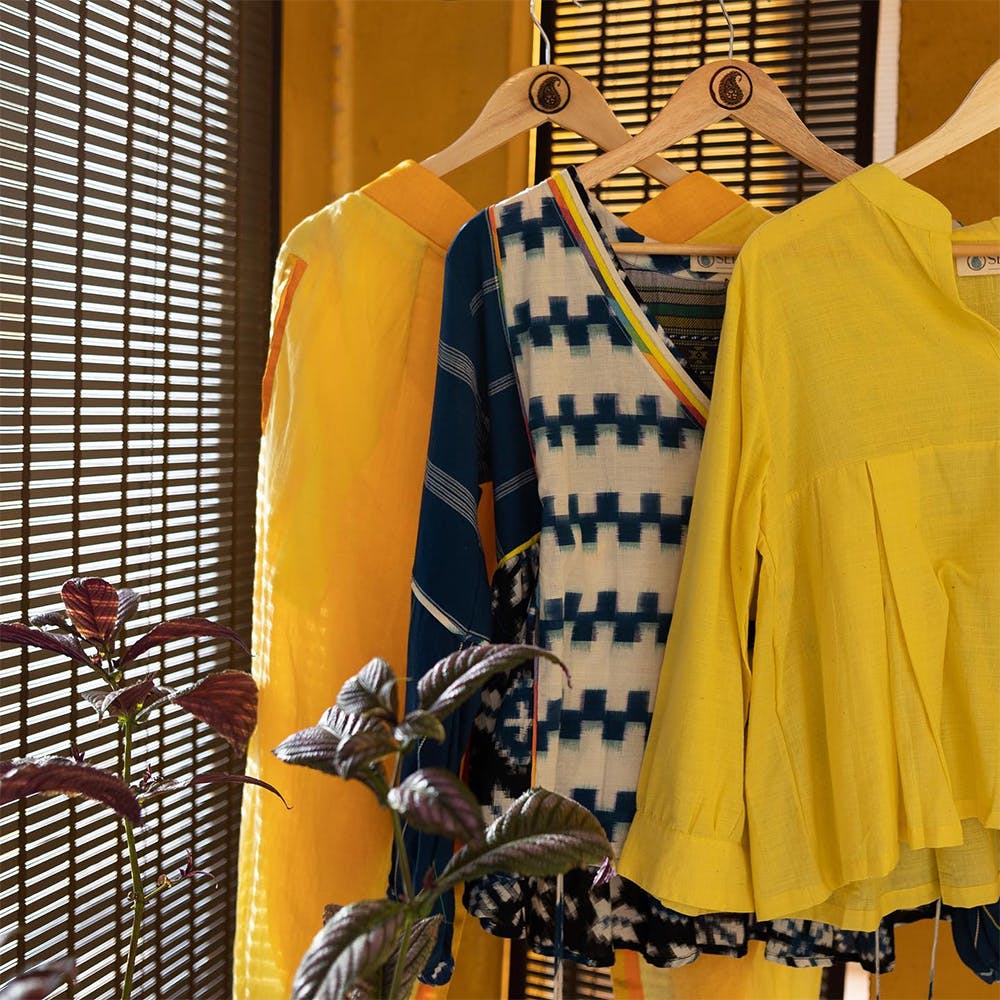 Sleeve,Yellow,Orange,Clothes hanger,One-piece garment,Sportswear,Fashion design,Blazer,Building,Pattern