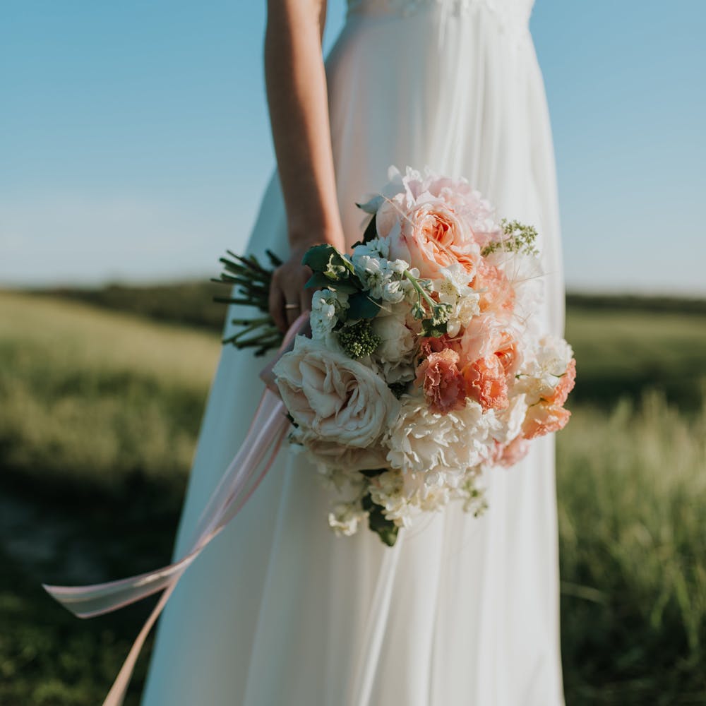 Clothing,Flower,Plant,Hand,Wedding dress,Dress,Petal,Bridal clothing,Sky,Bridal party dress