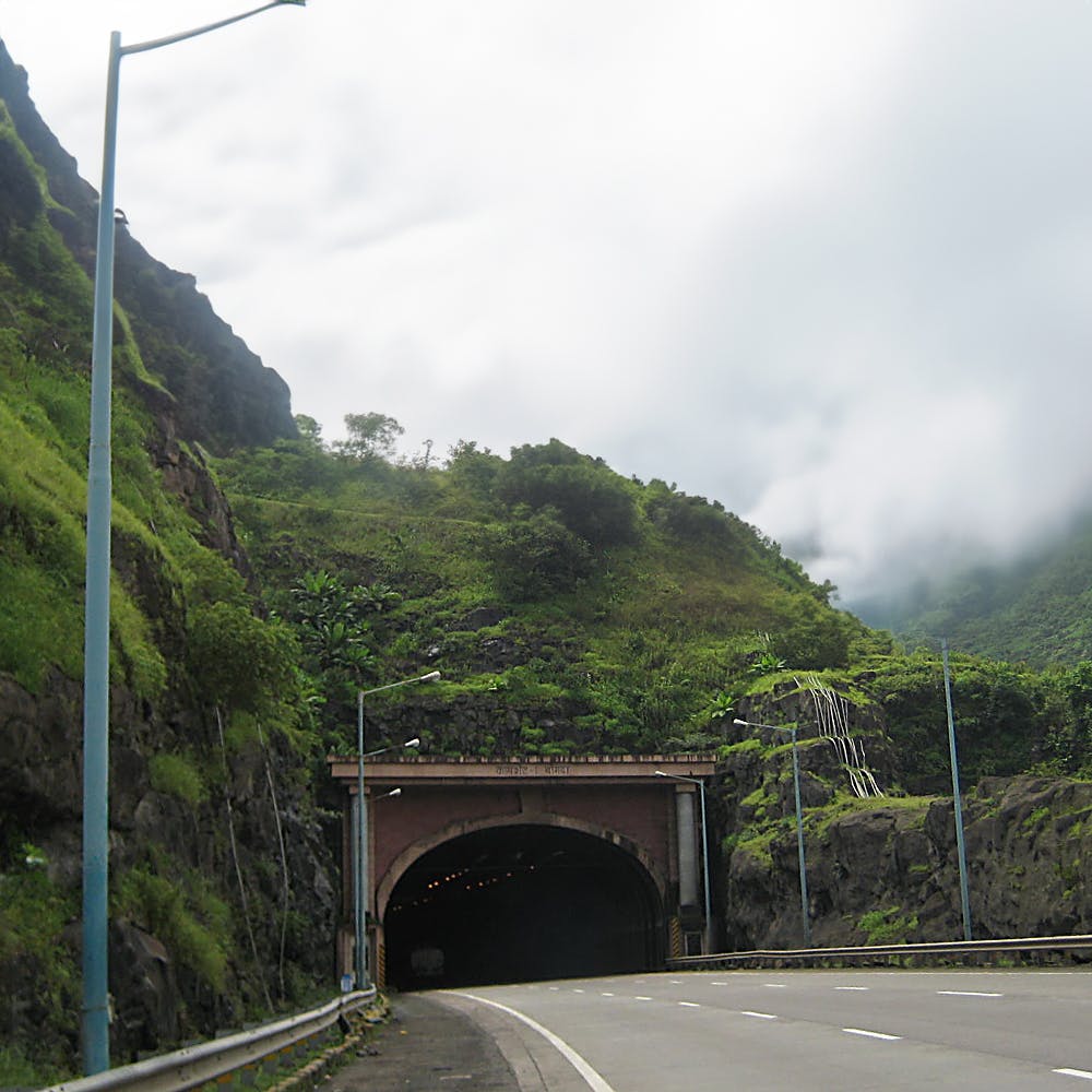 Cloud,Sky,Plant,Mountain,Highland,Infrastructure,Road surface,Slope,Vegetation,Asphalt