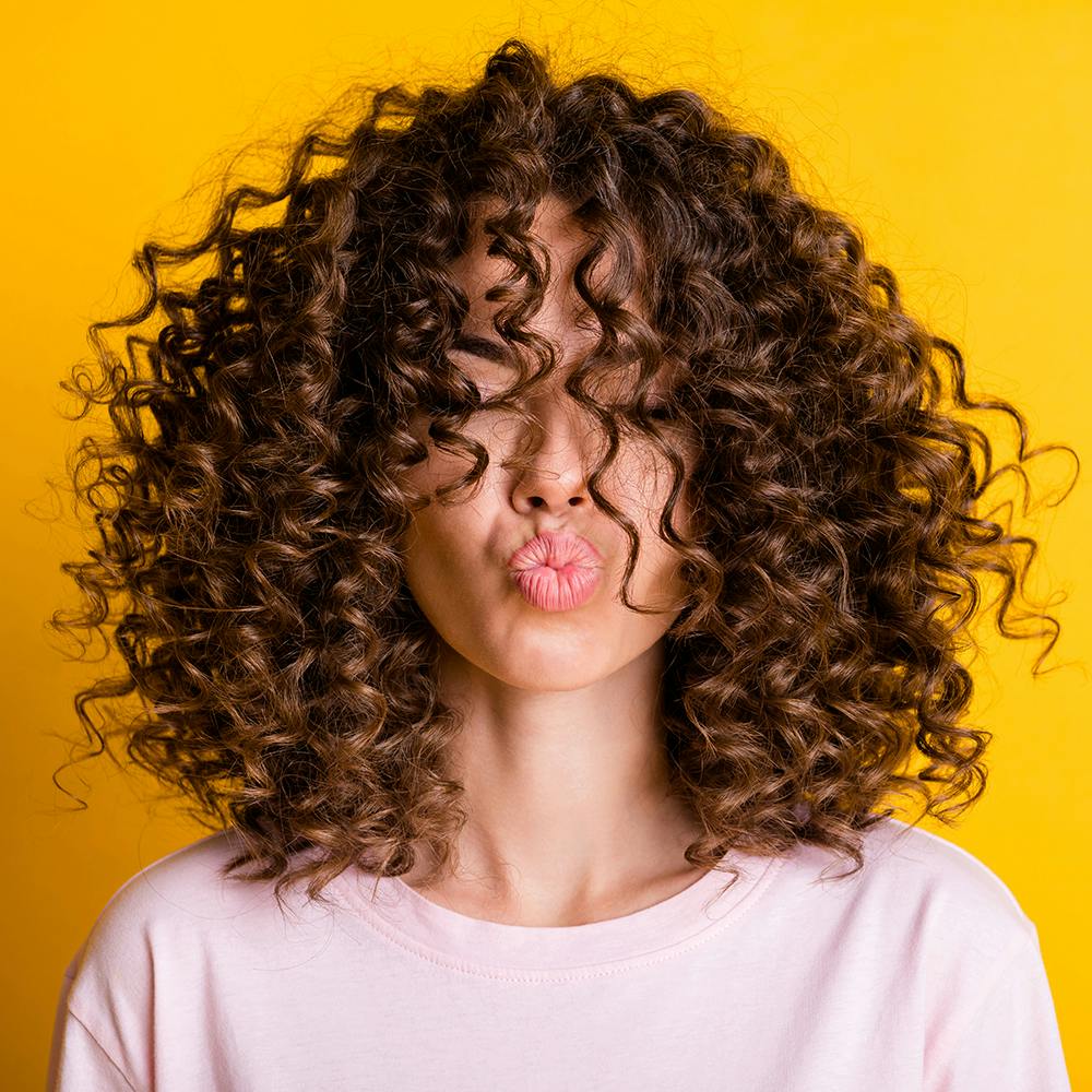 Forehead,Hair,Chin,Hairstyle,Eyebrow,Shoulder,Jheri curl,Ringlet,Human,Neck